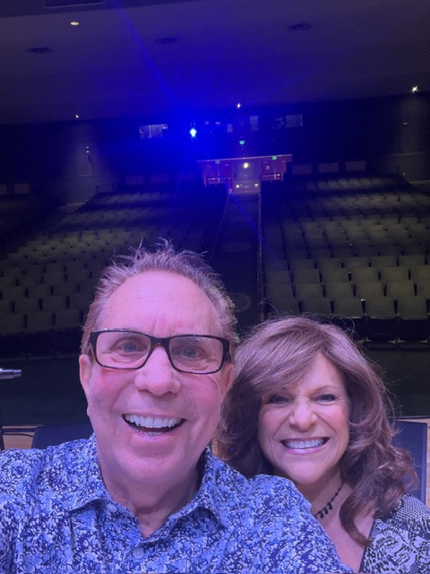Iris Revson and Michael Finkelstein smiling together in a theatre